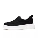 Chaussure homme noire tenue à la main détail finition