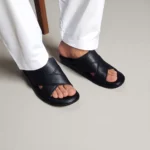 Sandales homme noires portées avec pantalon blanc