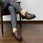 Mocassins homme en cuir véritable marron portés avec un pantalon élégant